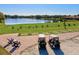 Driving range on a golf course with lake view, chairs and golf carts at 608 Misty Pond Ct, Bradenton, FL 34212