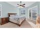 Bedroom with wooden bed, matching nightstands and dresser, and windows with blinds at 6215 Stillwater Ct, Bradenton, FL 34201