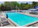 Community pool with crystal-clear water, lounge chairs, and shade umbrellas at 6215 Stillwater Ct, Bradenton, FL 34201