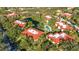 Aerial view of the community featuring red tile roofs, trees, pool, and a pond at 6462 Wild Oak Bay Blvd # 247, Bradenton, FL 34210