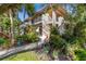 The front walkway leads to condo entrance with a lush, landscaped yard and palm trees at 6462 Wild Oak Bay Blvd # 247, Bradenton, FL 34210