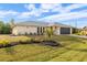 Single-story home with gray roof, black garage door, and landscaped yard at 7095 Larkin St, Englewood, FL 34224