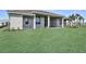 Grassy backyard featuring tropical trees, a covered patio, and meticulous landscaping at 8007 Nevis Run, Bradenton, FL 34202
