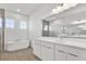 Modern bathroom with double vanity, glass shower, and soaking tub at 8007 Nevis Run, Bradenton, FL 34202