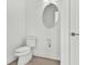 Clean bathroom with a toilet, simple mirror and tile flooring at 8007 Nevis Run, Bradenton, FL 34202
