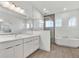 Modern bathroom with double vanity, glass shower, and soaking tub at 8007 Nevis Run, Bradenton, FL 34202