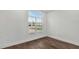 Bright bedroom featuring hard wood floors, white walls, and a large window showing neighborhood views at 8007 Nevis Run, Bradenton, FL 34202