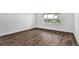 Empty bedroom with hardwood floors and a view of the neighborhood at 8007 Nevis Run, Bradenton, FL 34202