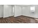Bedroom featuring wood floors, white walls, a window, and doorway to an en-suite bathroom at 8007 Nevis Run, Bradenton, FL 34202