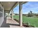 Covered patio with brick flooring shows space to relax while overlooking the grassy backyard and tropical landscaping at 8007 Nevis Run, Bradenton, FL 34202