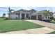 Attractive home featuring a lush green lawn, complemented by a paver driveway leading to the attached garage at 8007 Nevis Run, Bradenton, FL 34202