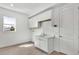 Bright laundry room featuring white cabinetry, a sink, and natural light from a window at 8007 Nevis Run, Bradenton, FL 34202