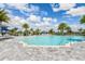 Community pool with beach entry, chairs, and a lake view on a sunny day at 8007 Nevis Run, Bradenton, FL 34202