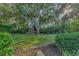 Private backyard with lush trees, manicured lawn, and landscaping at 114 Fieldstone Dr, Venice, FL 34292