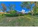 Spacious backyard with lush greenery, trees, and a view of the home at 114 Fieldstone Dr, Venice, FL 34292