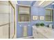 Blue bathroom featuring single vanity, shower and tub combo, and window with blinds at 114 Fieldstone Dr, Venice, FL 34292