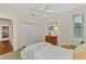 Spacious bedroom with white closet doors, wood dresser and bed, view to another room at 114 Fieldstone Dr, Venice, FL 34292
