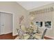 Dining area with a glass table, chandelier, and large windows at 114 Fieldstone Dr, Venice, FL 34292