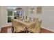 Elegant dining room with large window, wood floors, and stylish chairs at 114 Fieldstone Dr, Venice, FL 34292