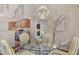 Dining area with glass-top table, stylish chandelier, and view of the kitchen at 114 Fieldstone Dr, Venice, FL 34292