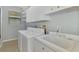 Laundry room with washer, dryer, sink, and upper cabinets for storage at 114 Fieldstone Dr, Venice, FL 34292