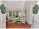 View of the living room through double doors, hardwood floors, and comfy furniture at 114 Fieldstone Dr, Venice, FL 34292