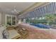 Covered patio with wicker seating overlooks the in ground pool at 114 Fieldstone Dr, Venice, FL 34292