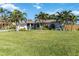 House with a large green lawn and palm trees in front at 1224 Pinebrook Way, Venice, FL 34285