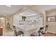 Efficient kitchen featuring white cabinets and breakfast bar at 1305 Glen Oaks E Dr # 130, Sarasota, FL 34232