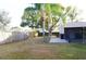 Fenced backyard featuring a large palm tree, green grass, and shade with a covered patio at 1416 Glenmere Dr, Brandon, FL 33511