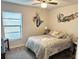 Stylish bedroom featuring mermaid wall art, modern ceiling fan, and laminated wood floors at 1416 Glenmere Dr, Brandon, FL 33511