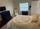 Bedroom with a window, TV, dresser, patterned bedding, and tufted chair at 1416 Glenmere Dr, Brandon, FL 33511