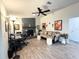 Spacious living room featuring a stone fireplace, ceiling fan, wood laminate flooring, and comfortable seating at 1416 Glenmere Dr, Brandon, FL 33511