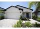 Modern two-car garage with gray accents and palm trees at 1424 Sunset Preserve Way, Port Charlotte, FL 33953