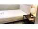 Contemporary bedroom with modern furniture, white bedding, and a stylish bedside lamp at 209 Dragons Fire Pl, Valrico, FL 33594