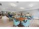 Community room with tables and teal chairs at 2522 Clubhouse Dr # 204, Sarasota, FL 34232