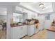 Bright kitchen with white cabinets, and view into adjoining living area at 2522 Clubhouse Dr # 204, Sarasota, FL 34232