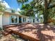 Large wooden deck with double doors and a detached garage in the background surrounded by mature trees at 2724 Ashton Rd, Sarasota, FL 34231