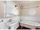 Classic bathroom with pedestal sink, clawfoot tub, and white wainscoting at 2724 Ashton Rd, Sarasota, FL 34231