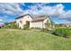 Exterior view of the home with a tile roof, landscaping, and a two-car garage at 27475 Janzen Ct, Englewood, FL 34223