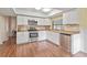 Modern white kitchen with stainless steel appliances and laminate flooring at 3001 Vivienda Blvd, Bradenton, FL 34207