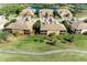 Gorgeous aerial view of community showcasing lush landscaping, palm trees, and serene lake at 318 Winding Brook Ln # 104, Bradenton, FL 34212