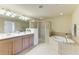 Bathroom with double vanity, walk-in glass shower, and separate soaking tub at 318 Winding Brook Ln # 104, Bradenton, FL 34212