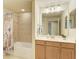 Bathroom with shower-tub combo with tile surround, and vanity with wood cabinets at 318 Winding Brook Ln # 104, Bradenton, FL 34212