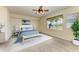Cozy bedroom with king bed, ceiling fan, palm tree artwork, and outdoor views at 318 Winding Brook Ln # 104, Bradenton, FL 34212