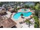 Community pool with lounge chairs and palm trees, near tennis courts and a clubhouse at 318 Winding Brook Ln # 104, Bradenton, FL 34212