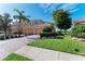 Exterior elevation of a home with paver driveway, lush lawn, and palm trees at 318 Winding Brook Ln # 104, Bradenton, FL 34212