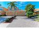 This charming home features a two-car garage, palm trees, and lush landscaping at 318 Winding Brook Ln # 104, Bradenton, FL 34212