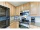 Close-up of the kitchen's stainless steel appliances and wood cabinetry at 318 Winding Brook Ln # 104, Bradenton, FL 34212