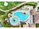 Aerial view of a resort-style pool and lush landscaping with golf course in the background at 318 Winding Brook Ln # 104, Bradenton, FL 34212